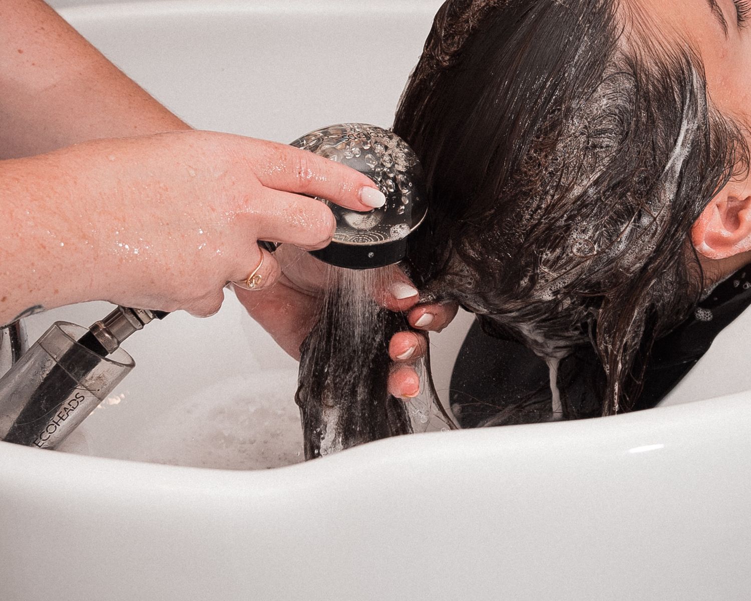 Soin capillaire en cours dans un salon, geste professionnel et texture des cheveux en lumière naturelle à Batz-sur-Mer