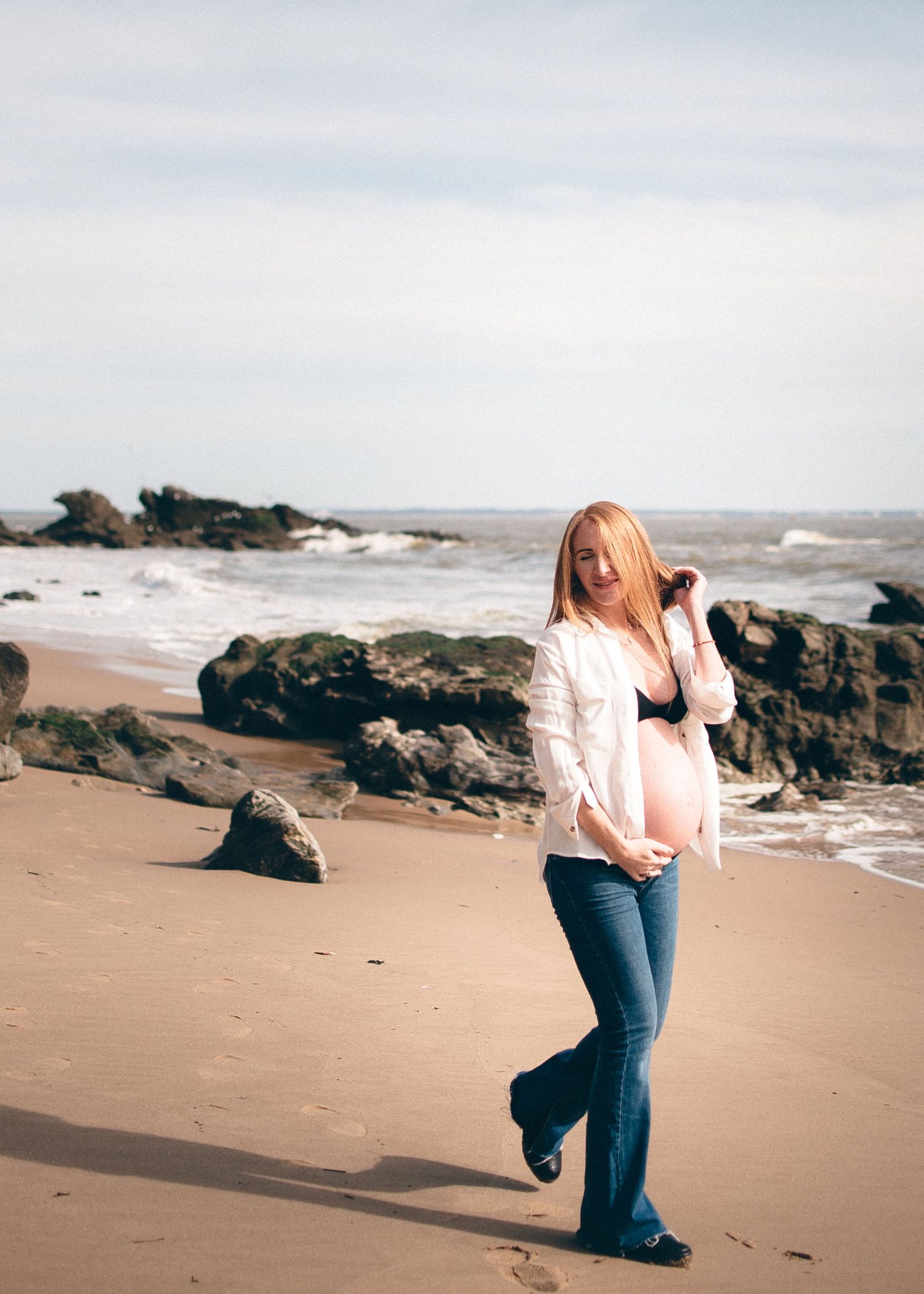 Femme enceinte marchant sur la plage, photographie de maternité naturelle en bord de mer à Saint-Nazaire