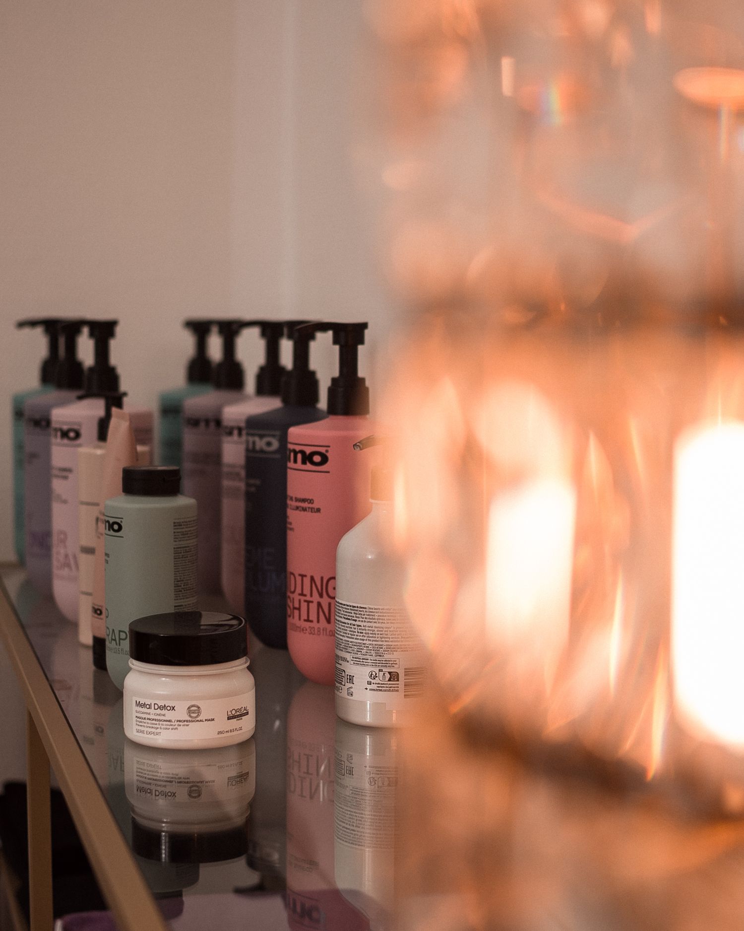 Produits de soins et cosmétiques disposés sur une étagère, photographiés en lumière naturelle avec une ambiance douce