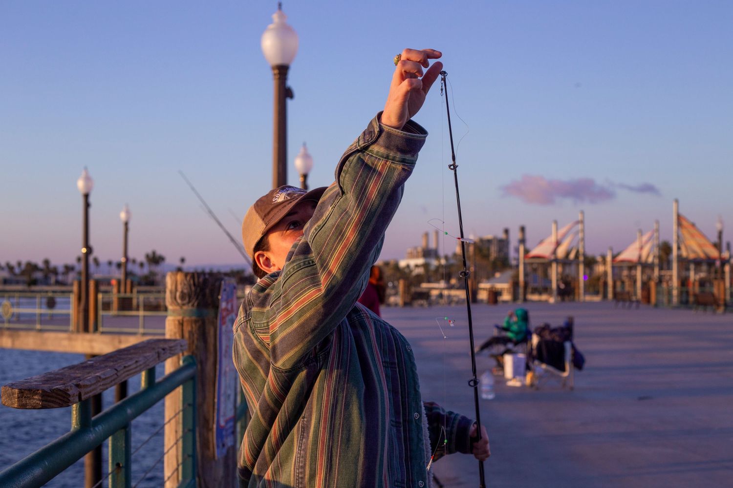 A series of fishing photos showing someone fishing off a pier at sunset with rods and tackle against a blue sky.
