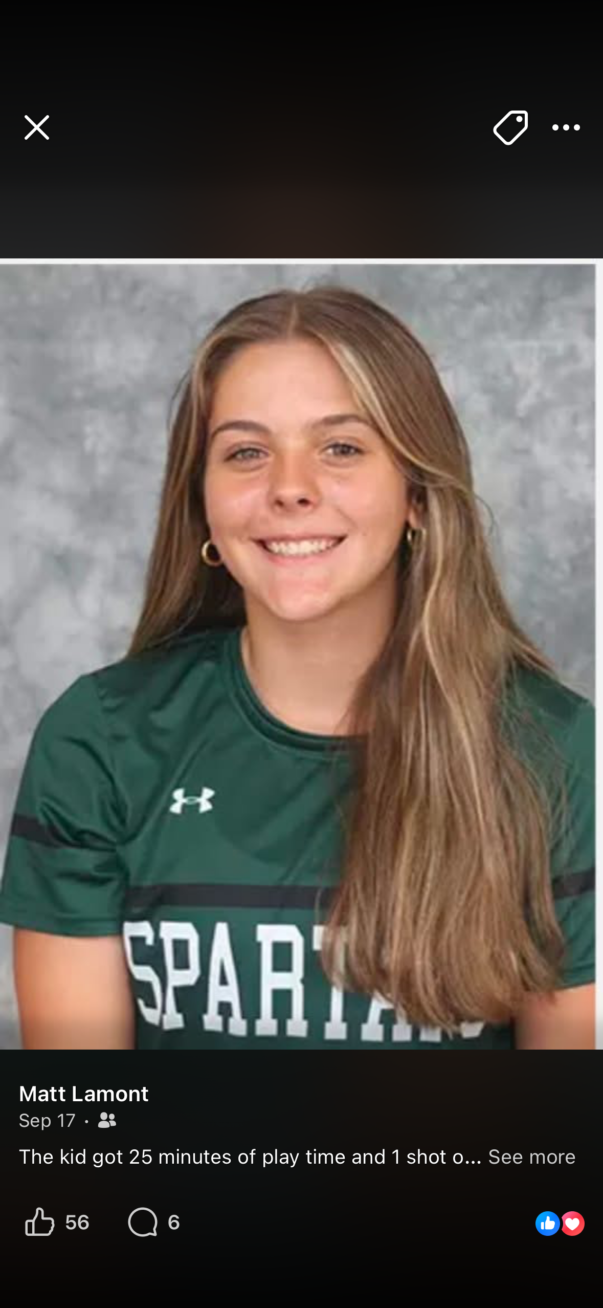 Young athlete in green Under Armour sports jersey smiling in a professional photo shoot setting.