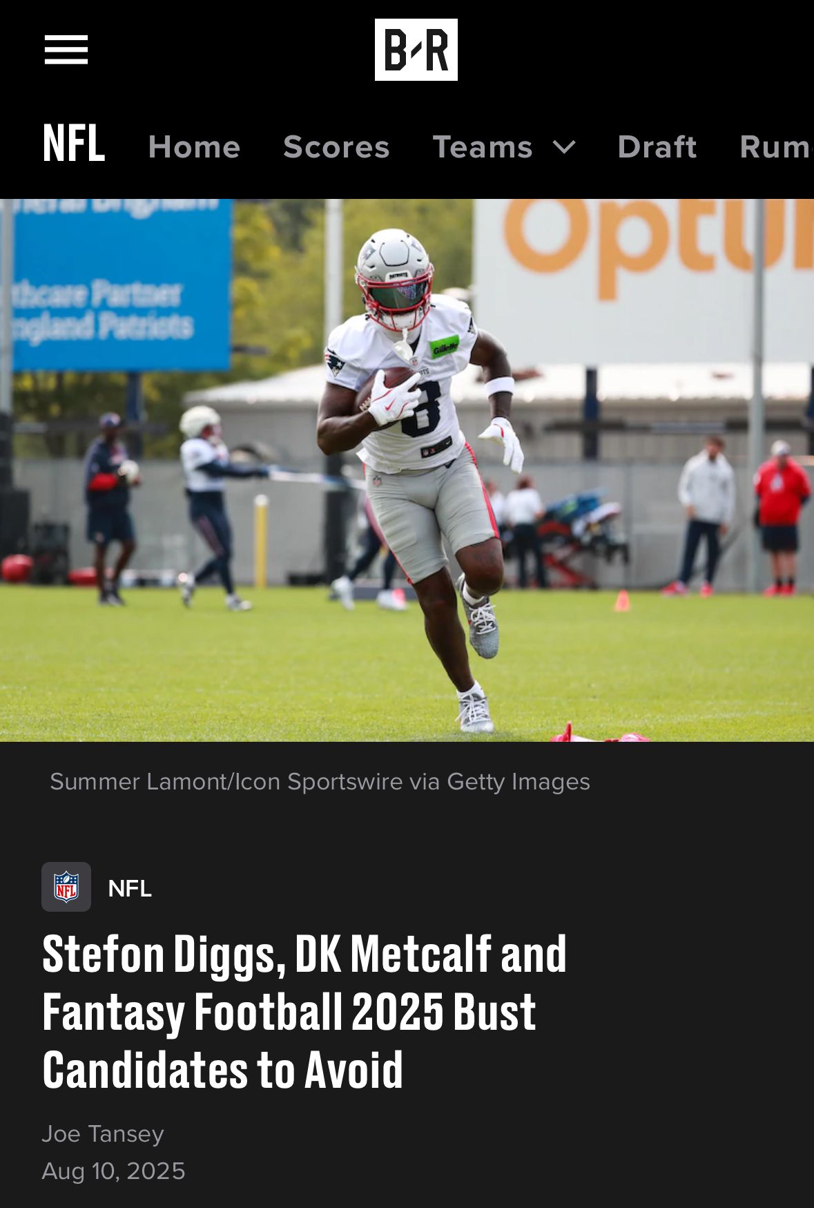 Football player runs with the ball during Patriots practice session on a cloudy day.