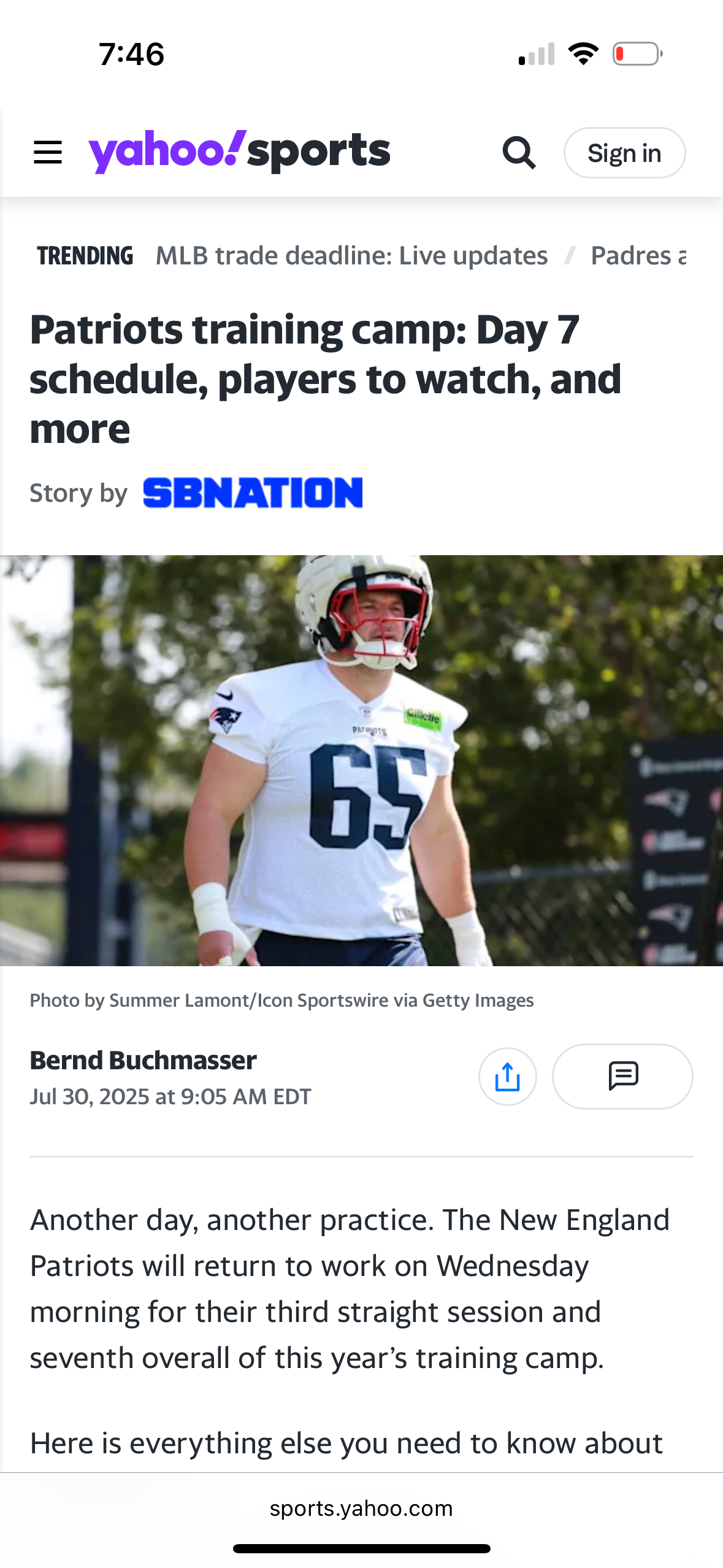 Patriots player in white jersey number 65 walks during training camp practice session.