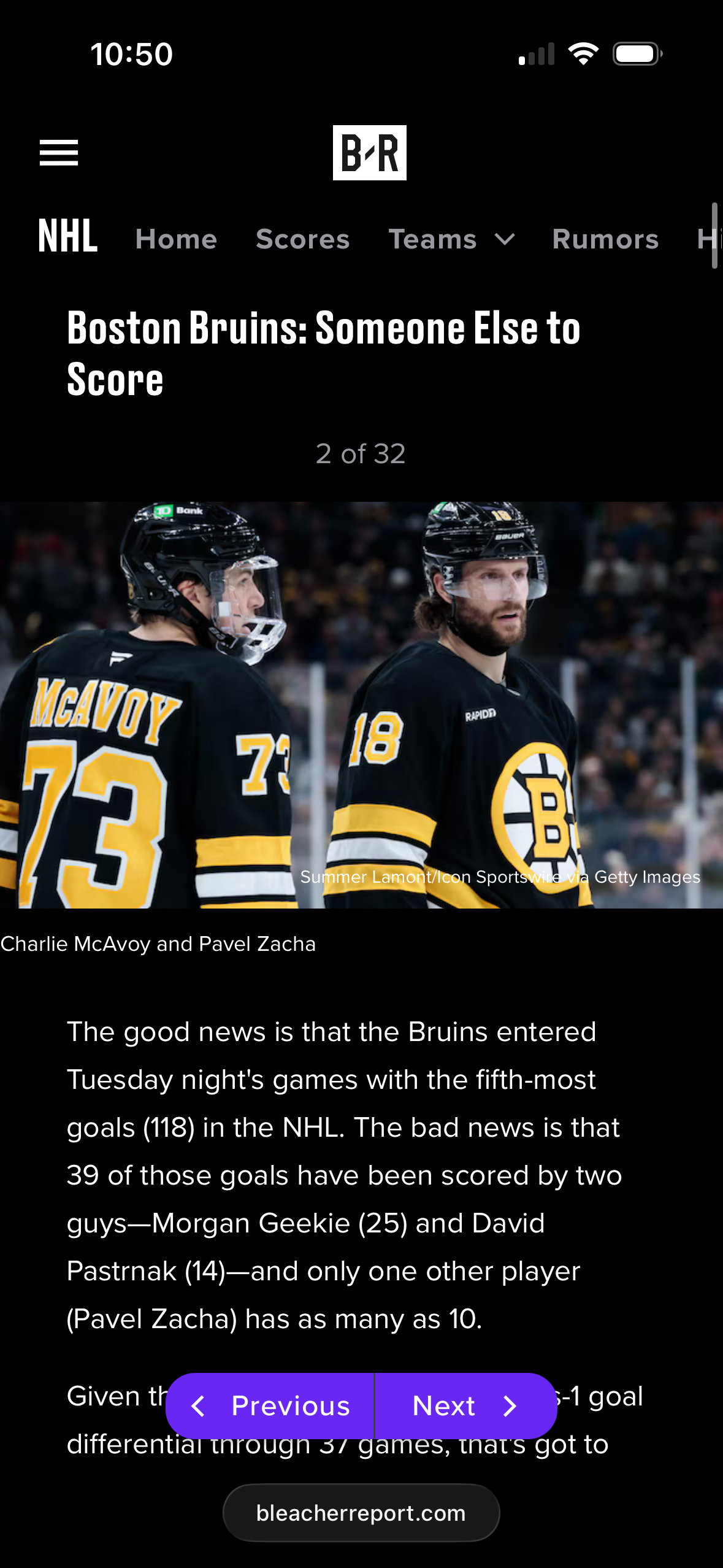 Two Boston Bruins hockey players in black and gold jerseys on the ice during NHL game.