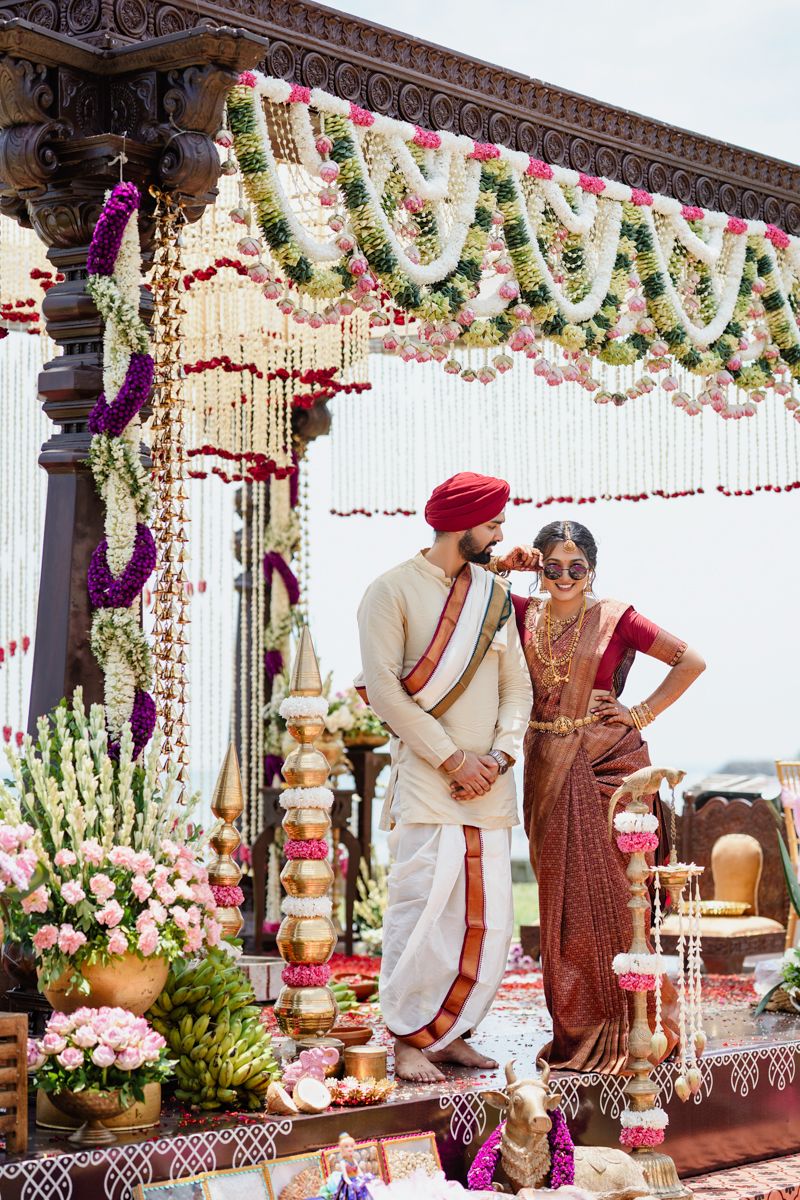 Traditional Indian wedding ceremony setup with ornate mandap decorated in white flowers and pink garlands.