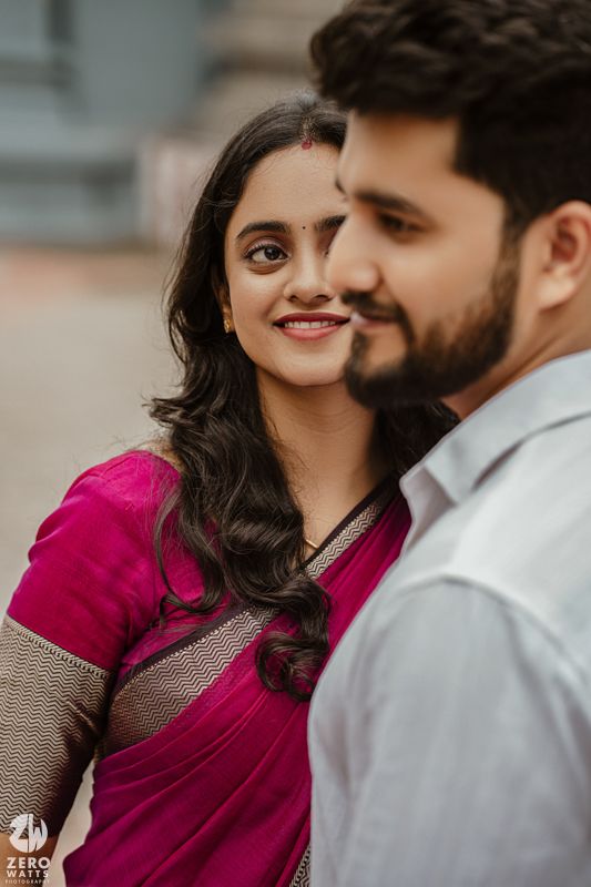 A couple in traditional Indian attire share intimate moments during a romantic photoshoot outdoors.