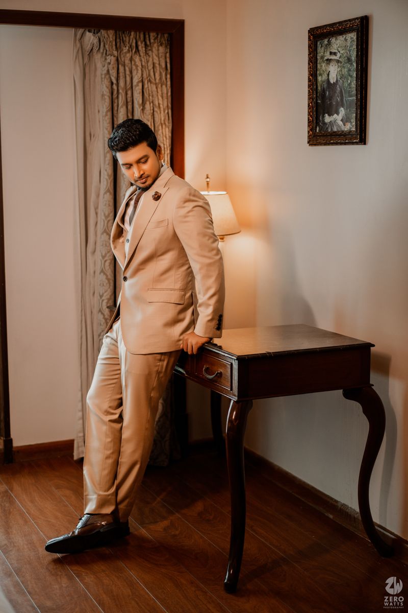 A series of wedding photos featuring a groom in a beige suit posing against a dark wood backdrop.