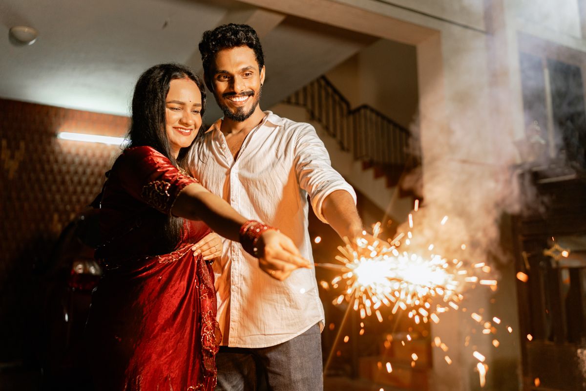 Couple celebrating with sparklers at night creating a magical atmosphere.