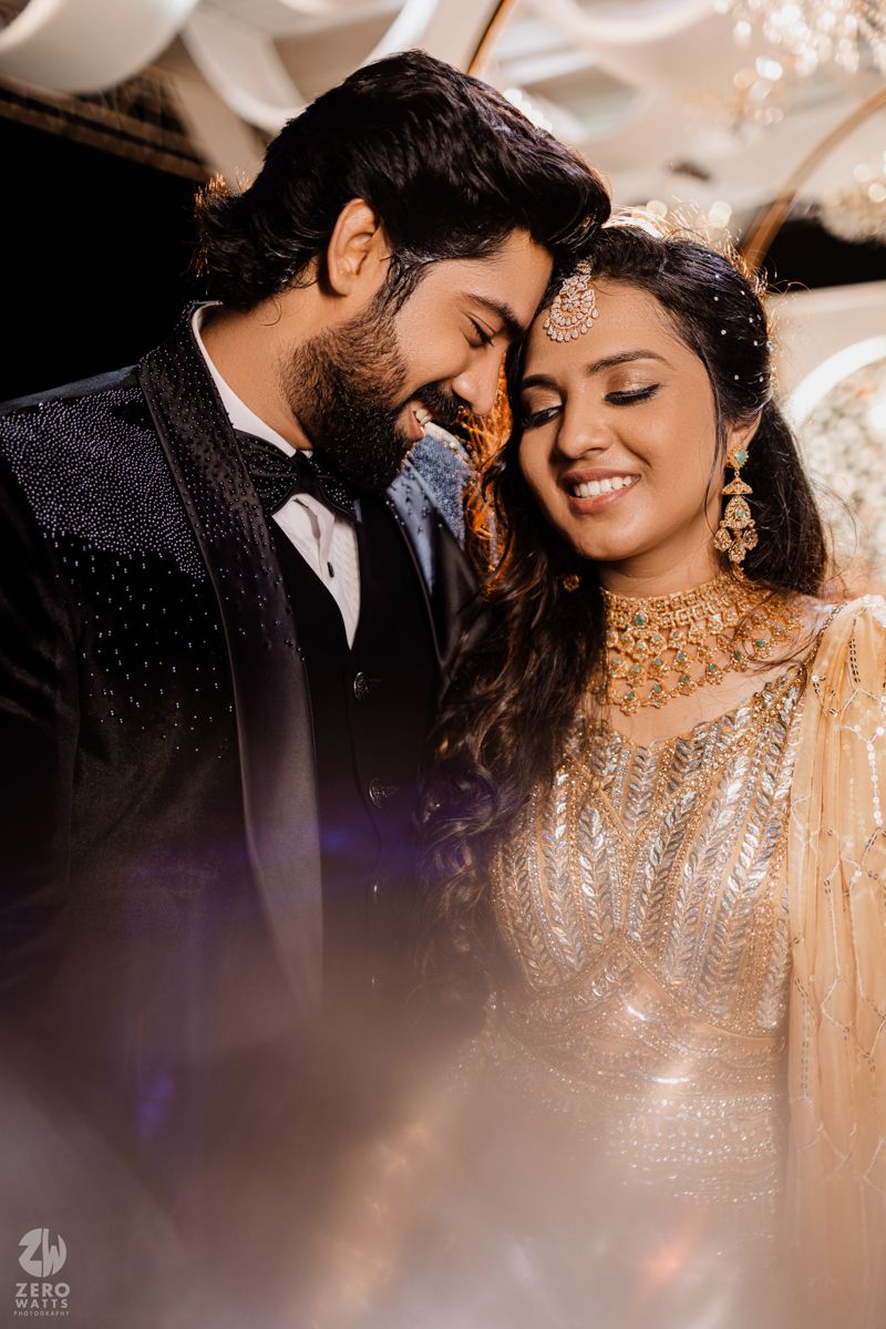 An intimate wedding portrait captures a tender moment between newlyweds in traditional Indian formal wear.