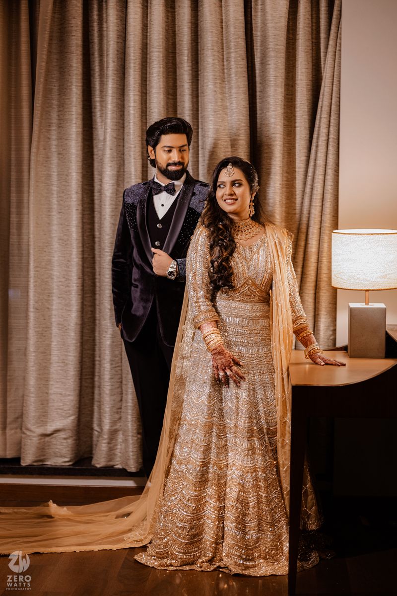 A couple poses in elegant wedding attire featuring a sparkly gown and velvet tuxedo.