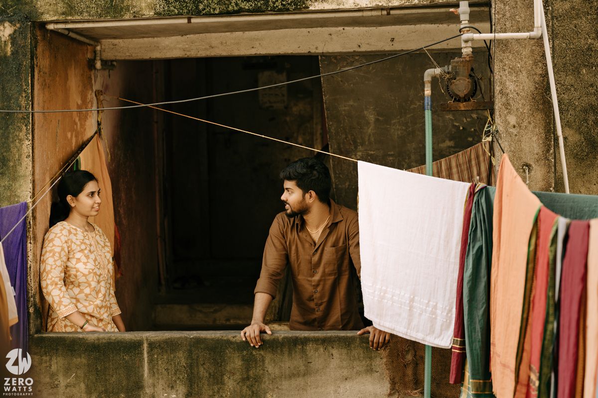 Clotheslines with colorful laundry hanging between buildings in an urban alley setting.