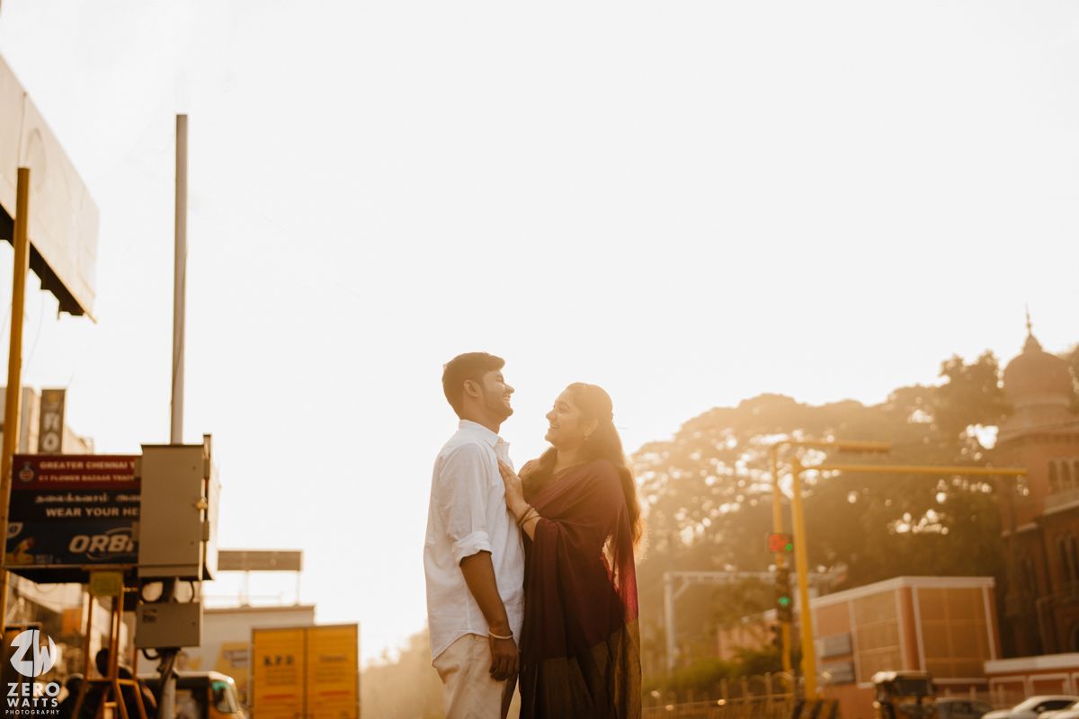 Couple sharing a tender moment against the backdrop of Mumbai's historic architecture at dusk.