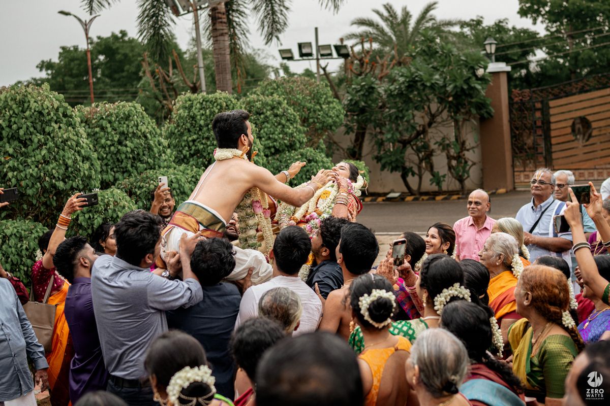 Crowd of wedding guests gathered outdoors participating in traditional Indian wedding rituals.