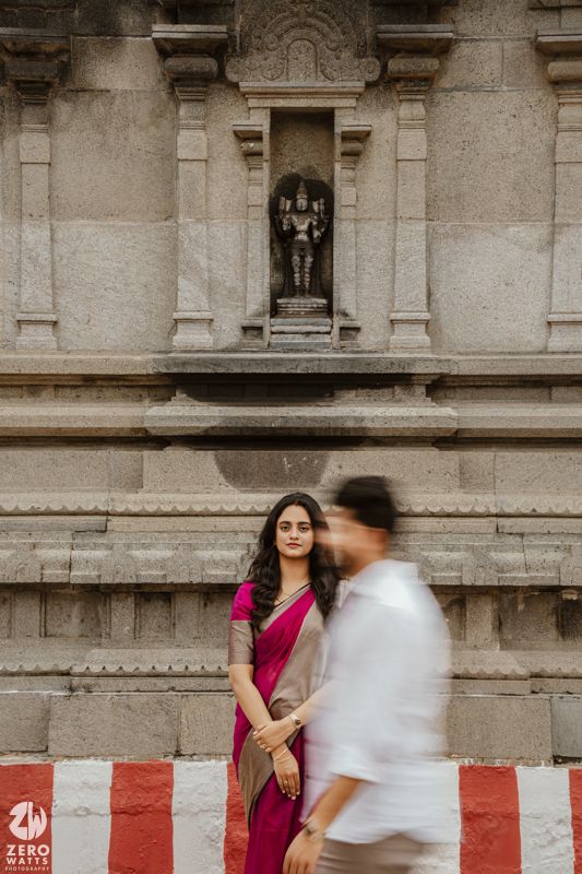 Artistic temple photoshoot with motion blur effect against stone architecture and red and white barriers.