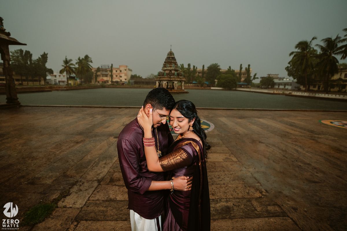 Romantic photoshoot on a temple terrace with traditional Indian architecture in the background.