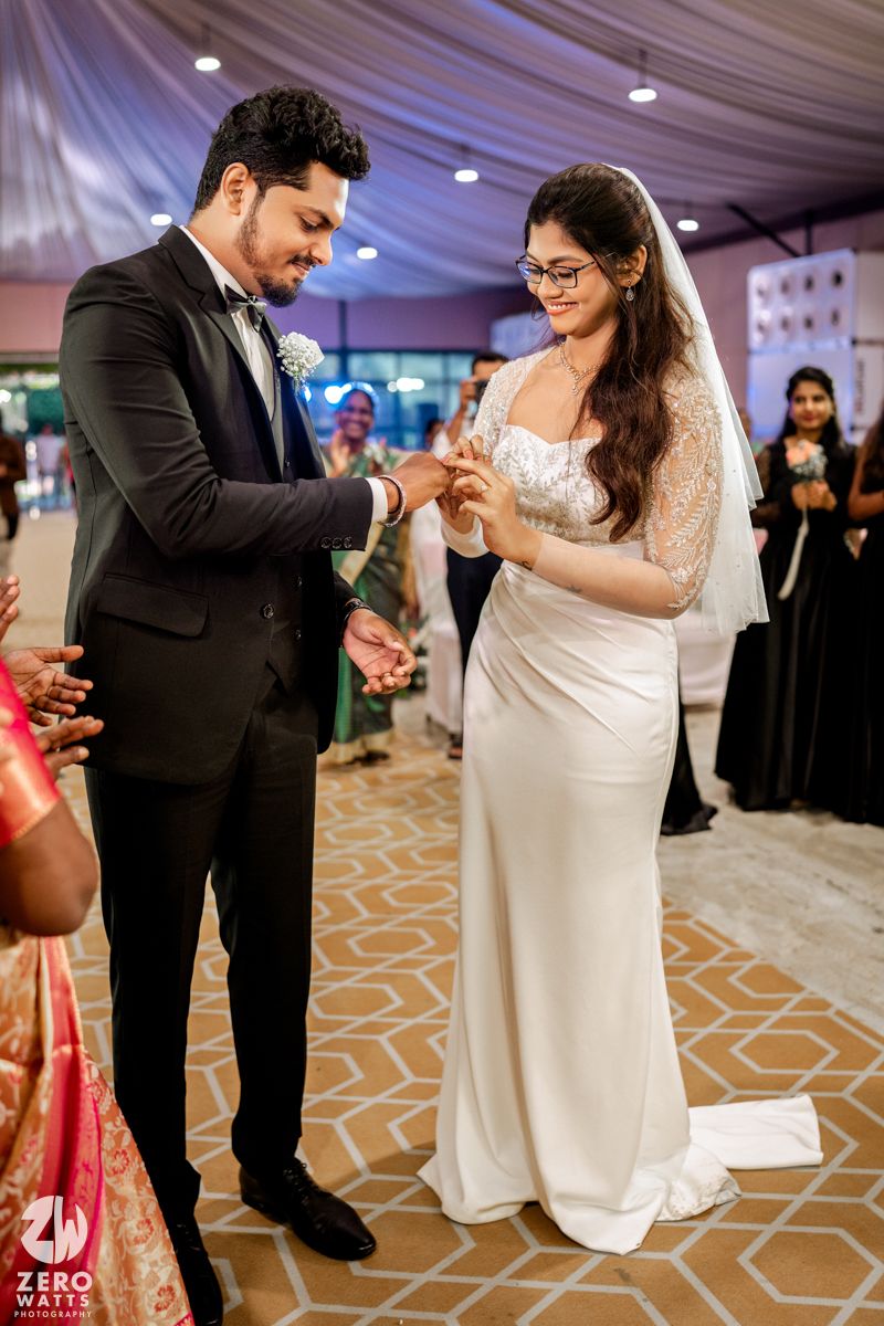 A couple shares their first dance at a wedding reception in an elegant ballroom with geometric patterned carpet.