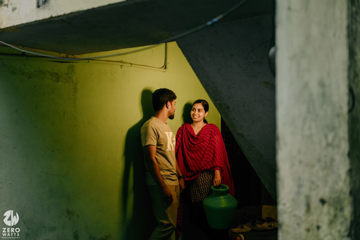 People gather in a dimly lit hallway with yellow-green lighting creating an atmospheric mood.
