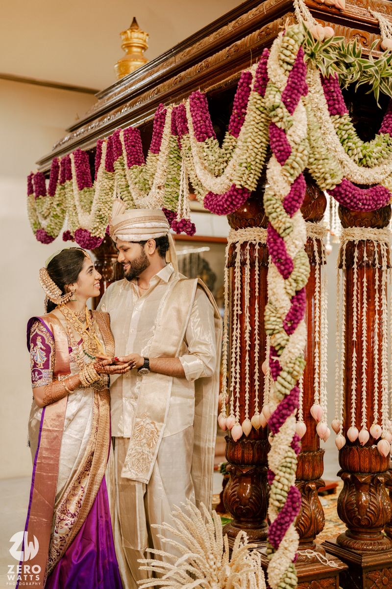 Traditional Indian wedding ceremony with decorative floral garlands and ornate mandap decorations.