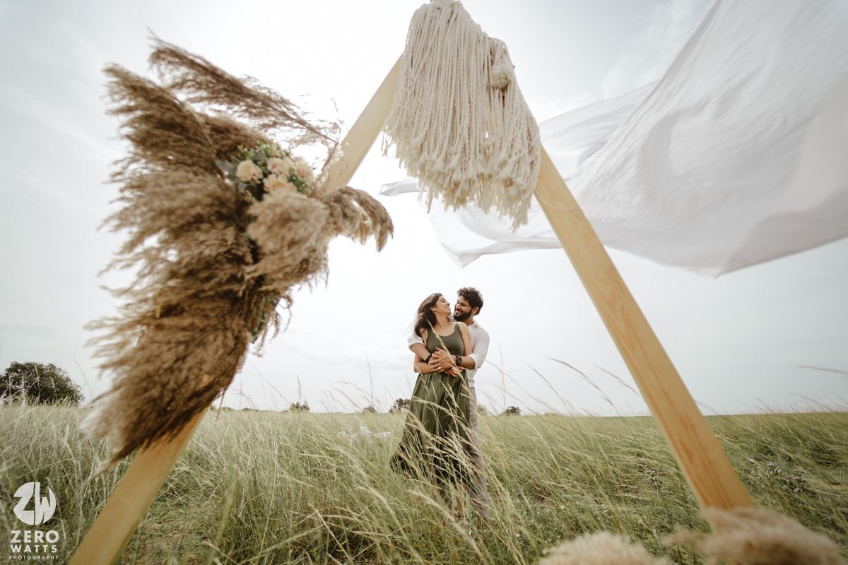White fabric canopy billowing in the wind against a natural grassland landscape.