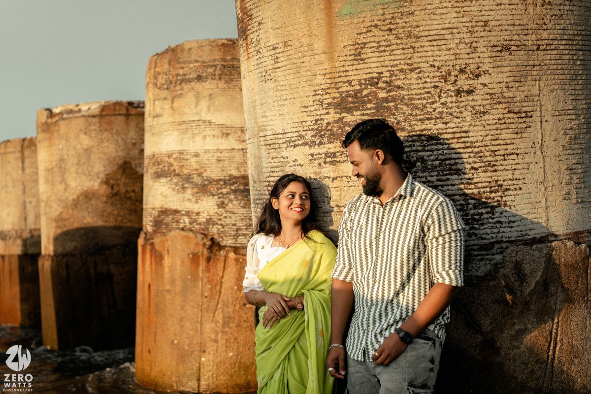 Romantic couple poses against ancient stone fortress walls during golden hour photoshoot.