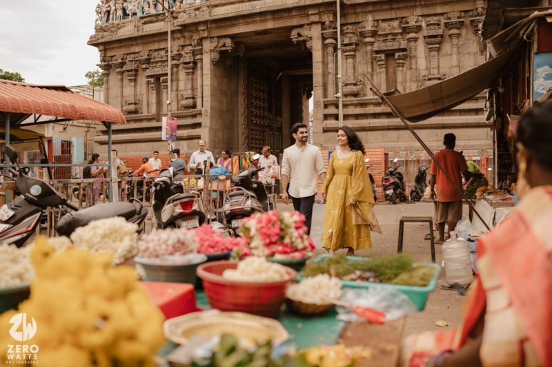 Traditional Indian marketplace with vendors displaying fresh produce and goods under ornate stone archways.