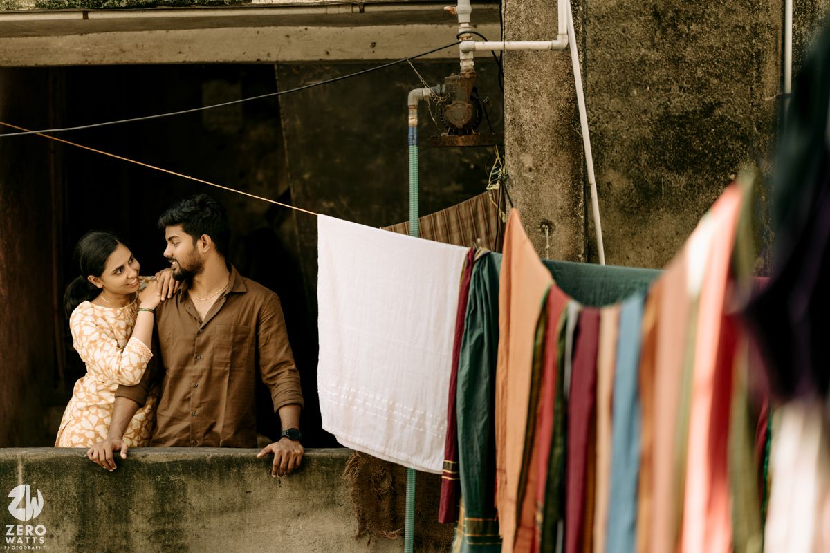 Clotheslines with laundry strung between buildings in a sepia-toned urban scene.