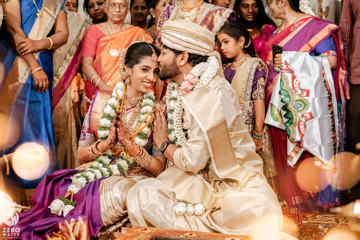 Joyful wedding celebration with guests in traditional attire under elegant decorations.