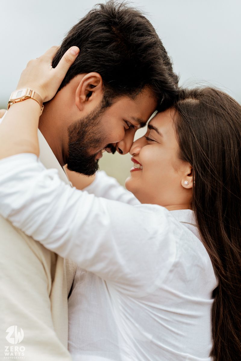 A couple shares intimate close-up moments while wearing white shirts against a light background.