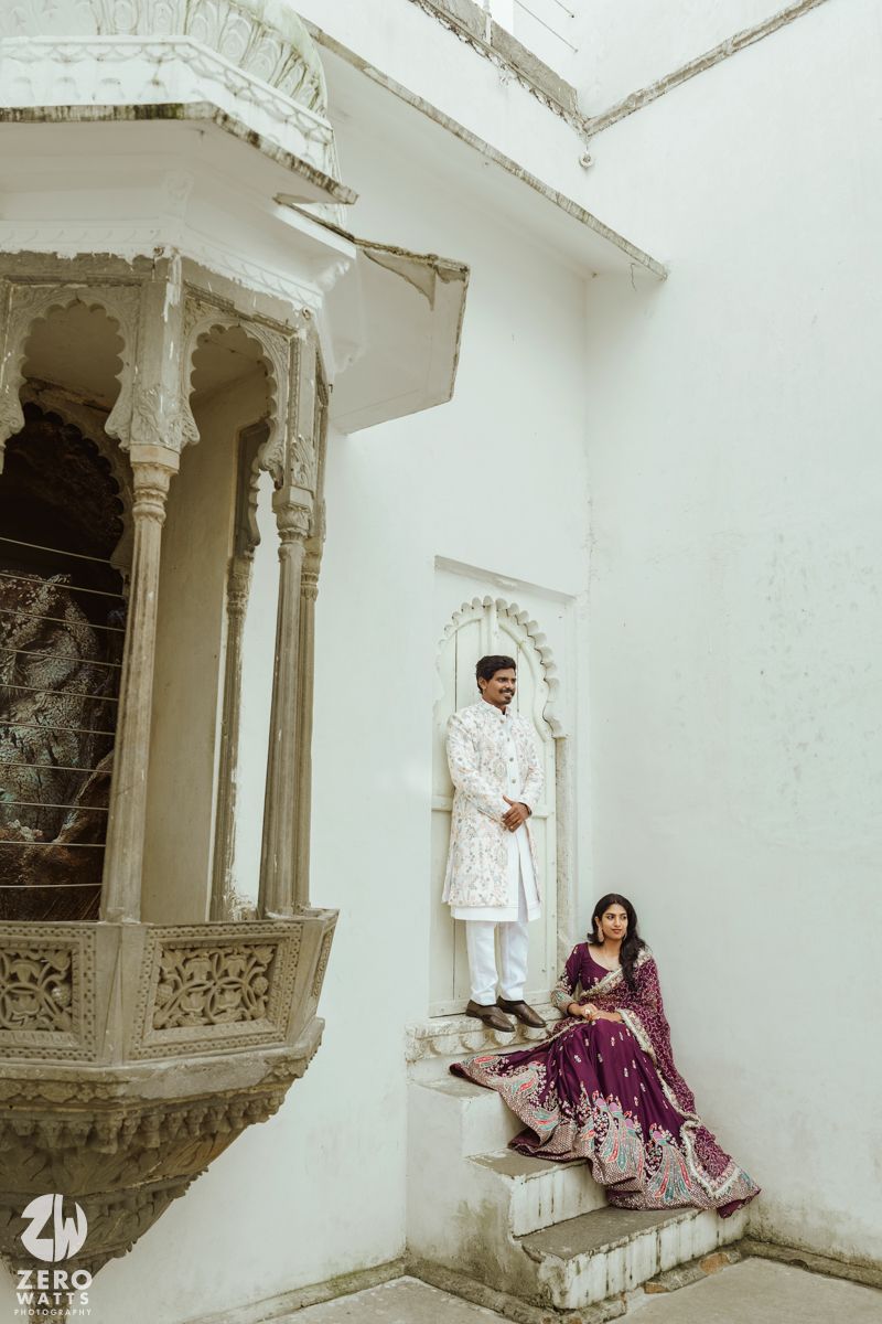 Traditional wedding photoshoot in a white palace interior with ornate architectural details.