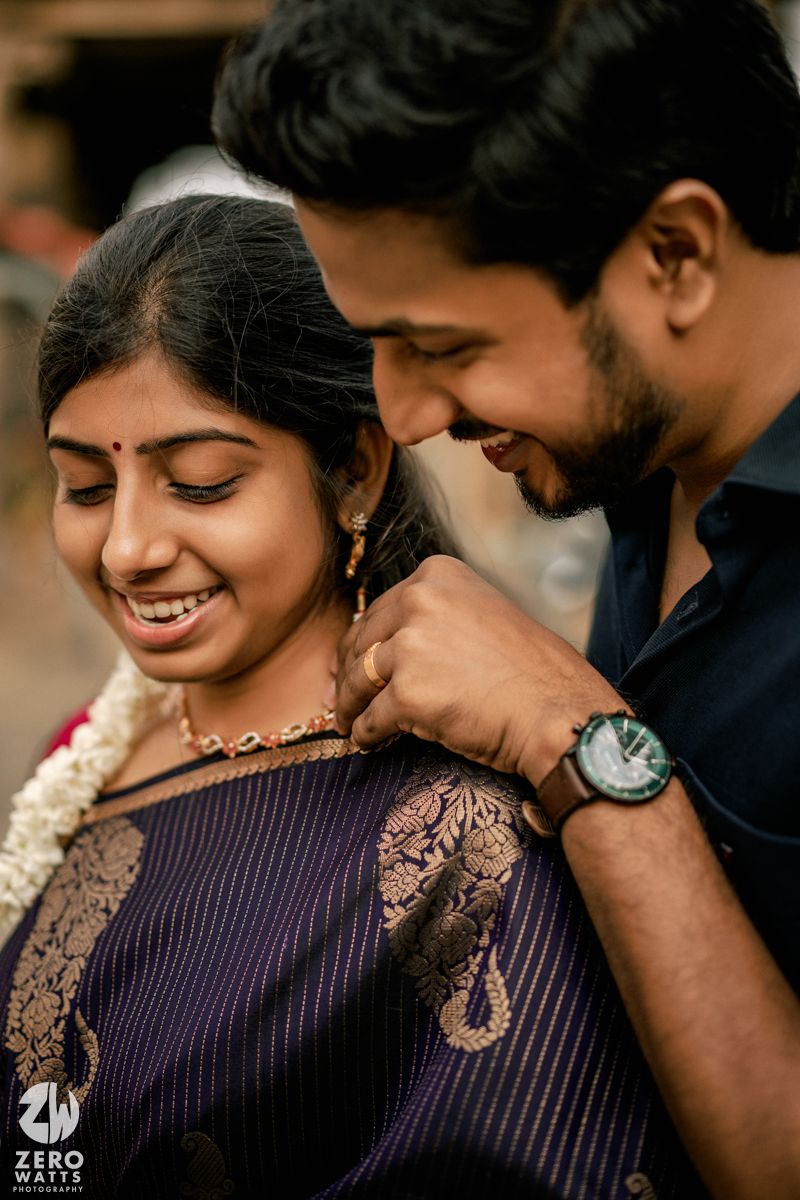 A romantic moment captured between two people in traditional Indian dress with purple and black attire.