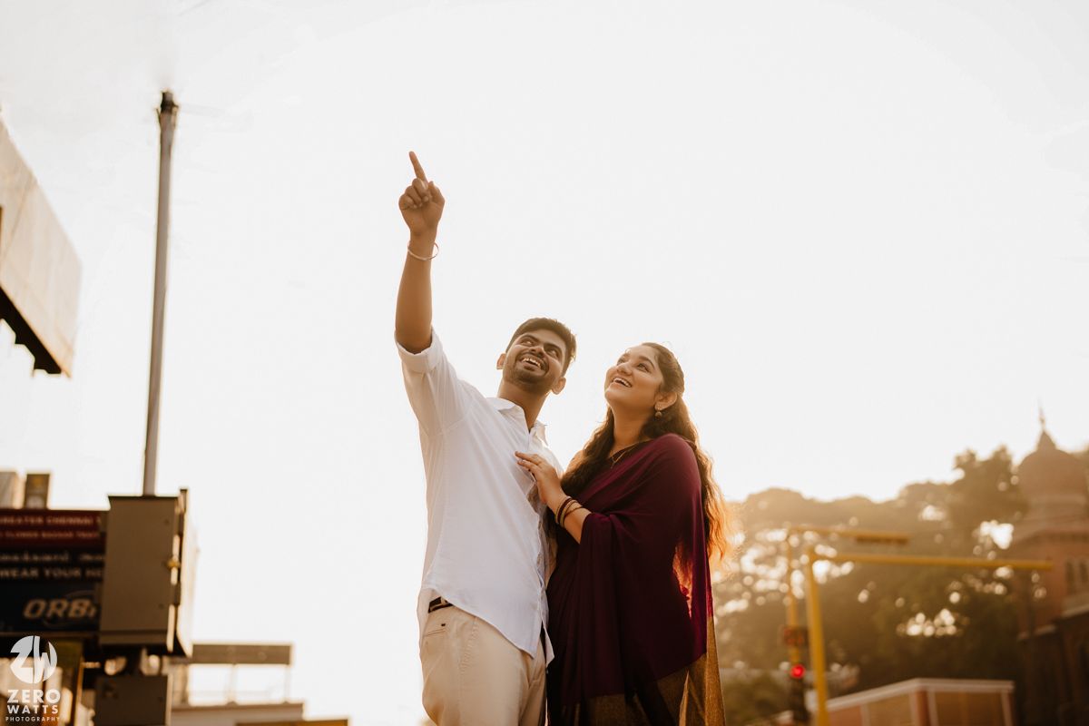A joyful interaction between two people with historic architecture silhouetted in the background.