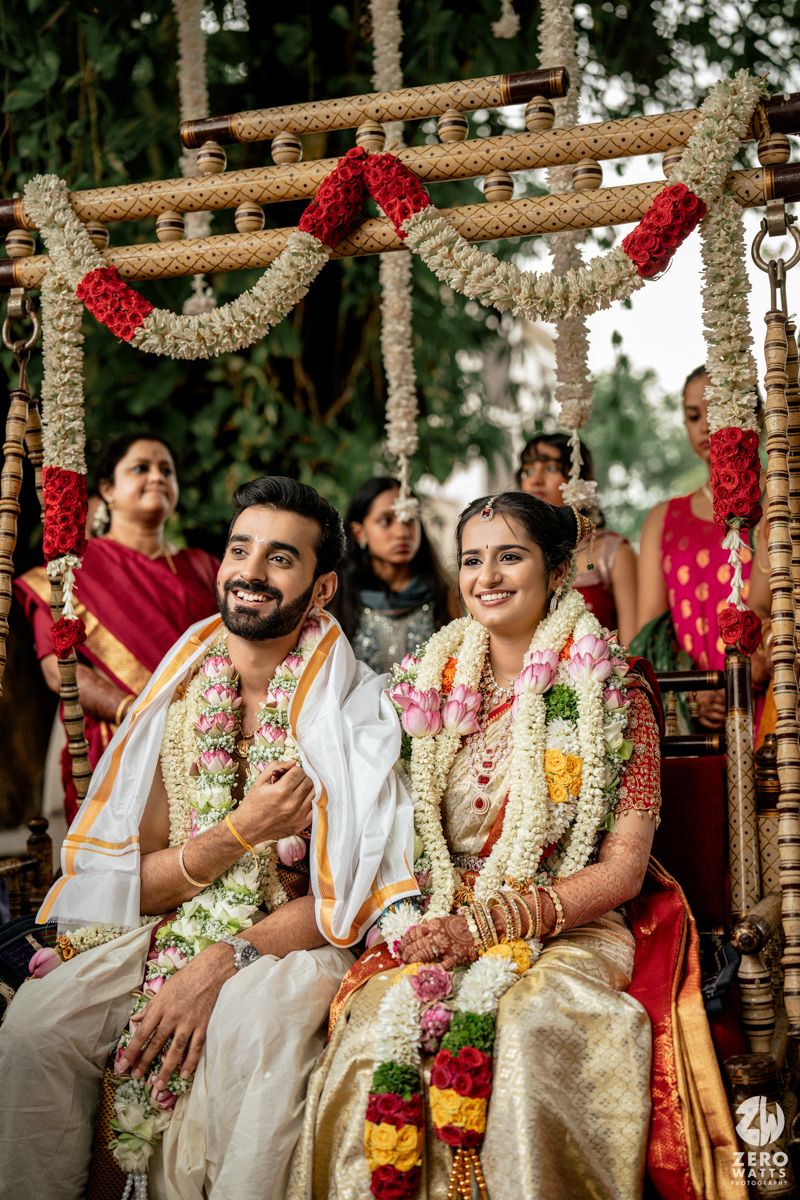 Traditional Indian wedding ceremony with decorated mandap and floral arrangements under trees.