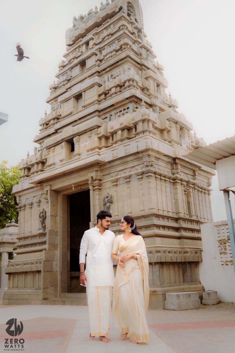 Traditional South Indian temple architecture with ornate white stone gopurams serves as backdrop for a cultural photoshoot.