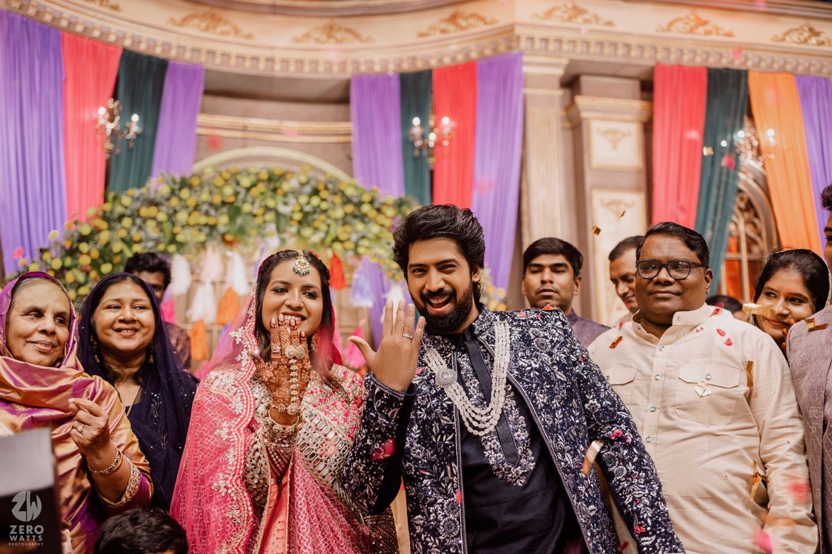 Festive Indian wedding celebration with colorful draped decorations and joyous group gathering.