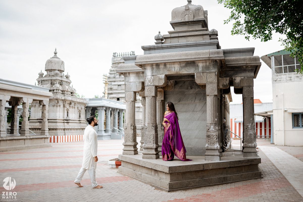 Ancient temple architecture with white stone pillars and walkways under cloudy sky.