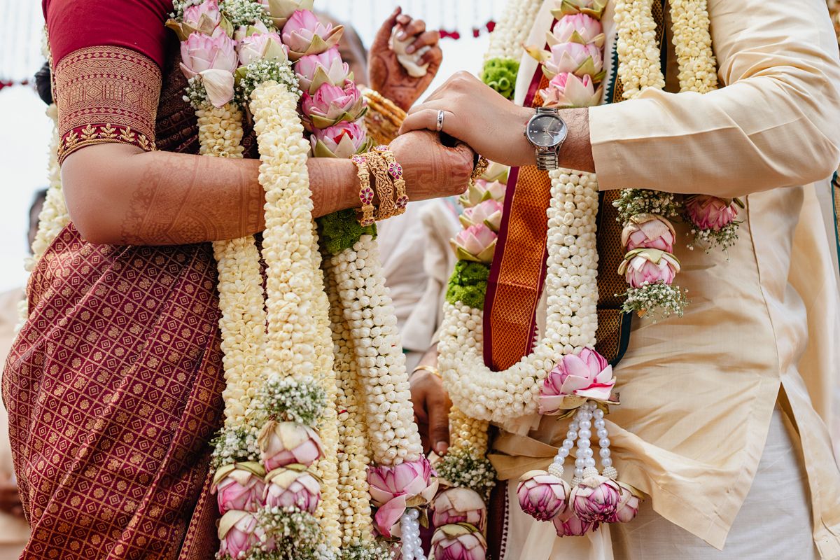 Wedding ceremony details showing traditional garlands and decorations in cream and pink colors.