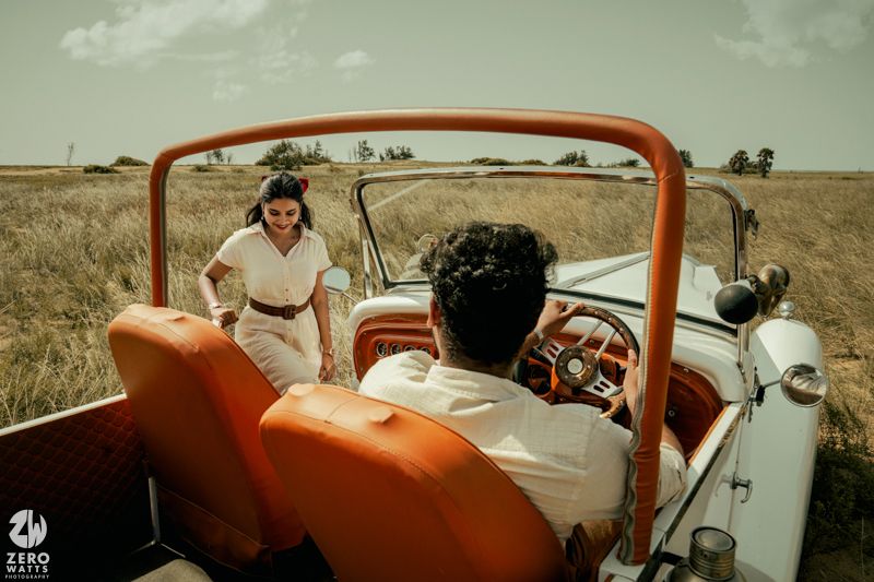 Vintage-styled photo of a classic car with orange and white color scheme in natural setting.