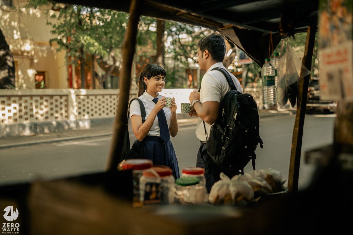 Students gathered outside brick building on campus with backpacks in warm afternoon light.