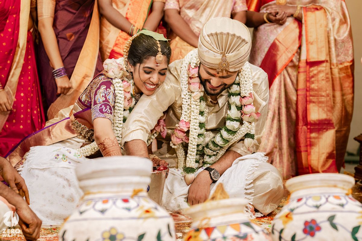 Traditional Indian wedding ceremony ritual with decorative pots and floral arrangements.