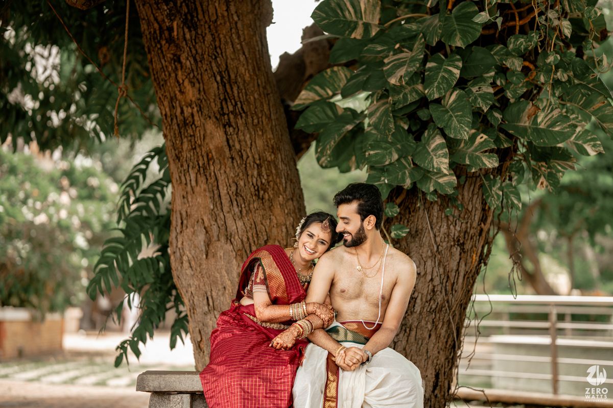Outdoor wedding photoshoot under a large tree with natural greenery.