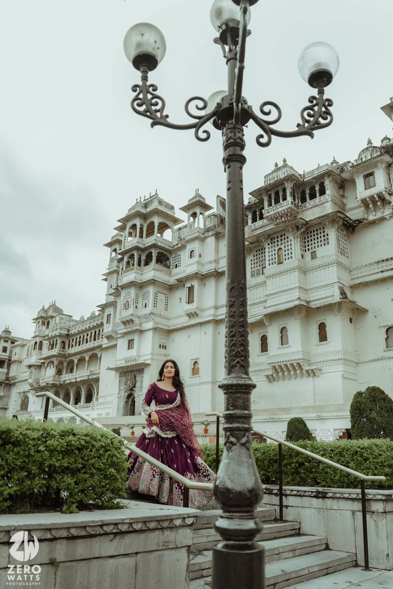 Dramatic fashion photography showcasing traditional attire against the majestic City Palace of Udaipur.