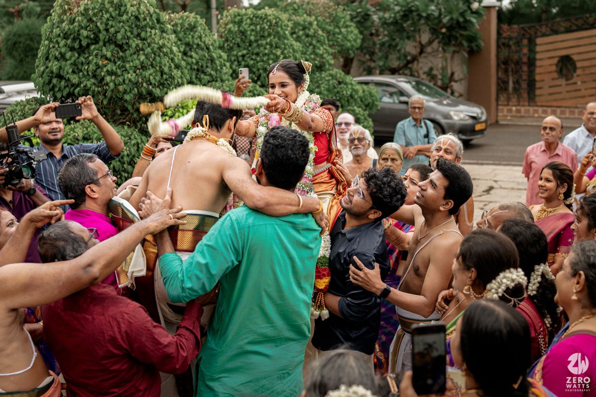 Wedding guests dancing and celebrating during a traditional Indian ceremony outdoors.