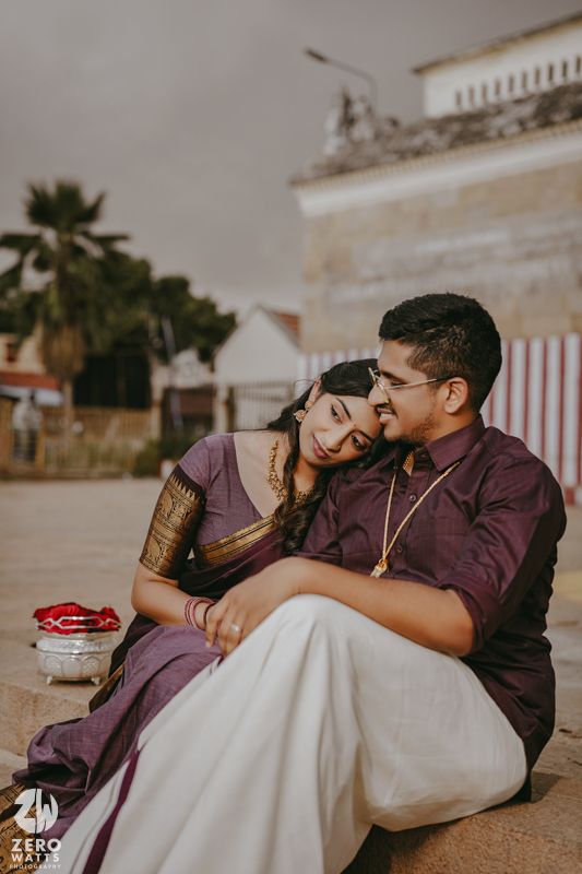 A couple in burgundy and white outfits share intimate moments in a romantic outdoor photoshoot.