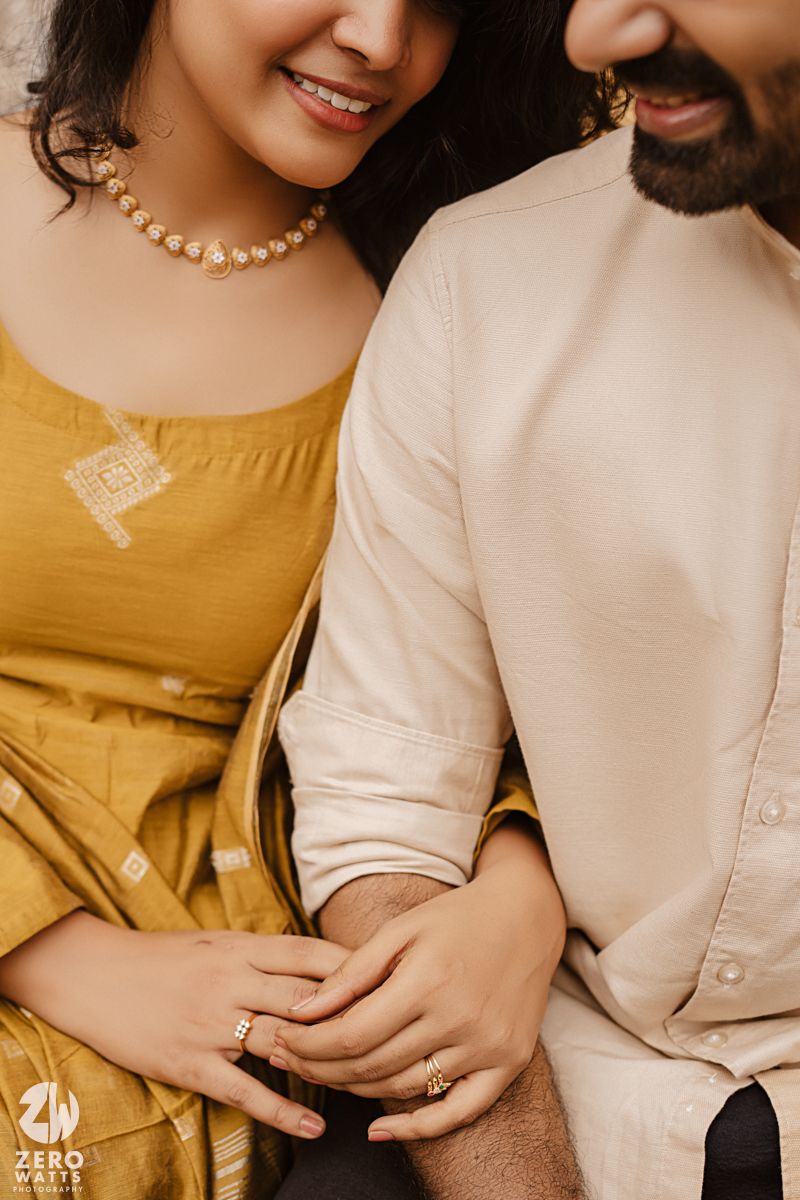 Close-up shot of traditional Indian jewelry and clothing details in mustard yellow and cream colors.