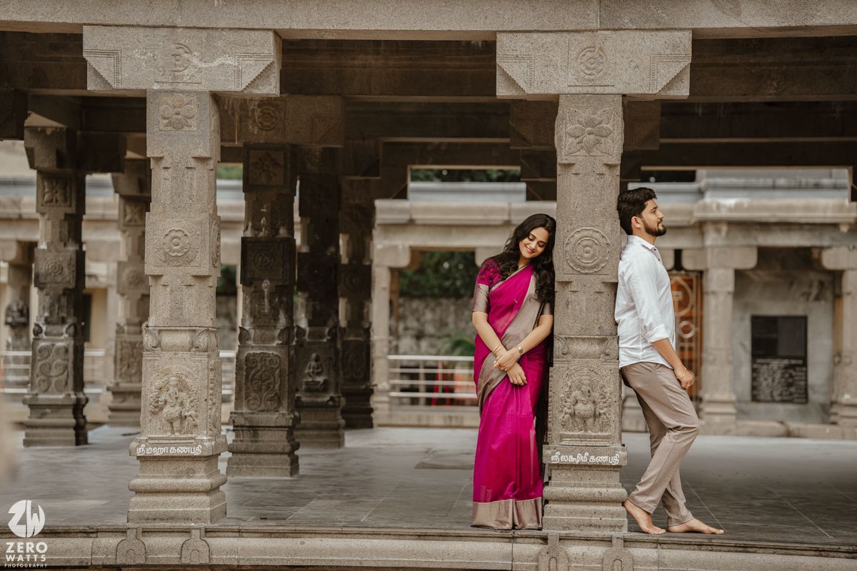 Stone pillars and archways frame a distant view of temple architecture.