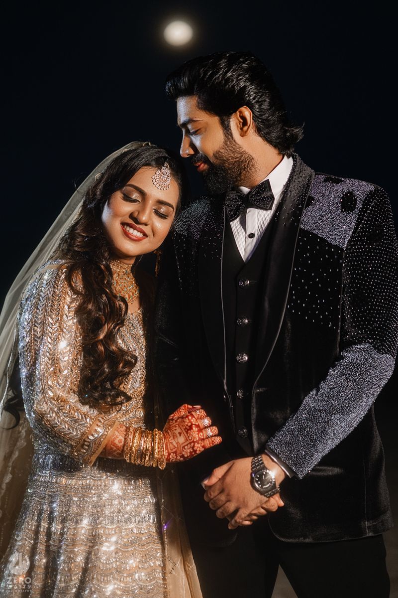 A romantic couple in wedding attire share intimate moments in a dark setting with glowing lights.