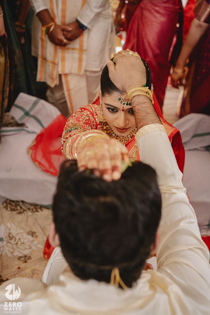 A traditional Indian wedding ceremony shows a couple performing rituals with their hands joined together.