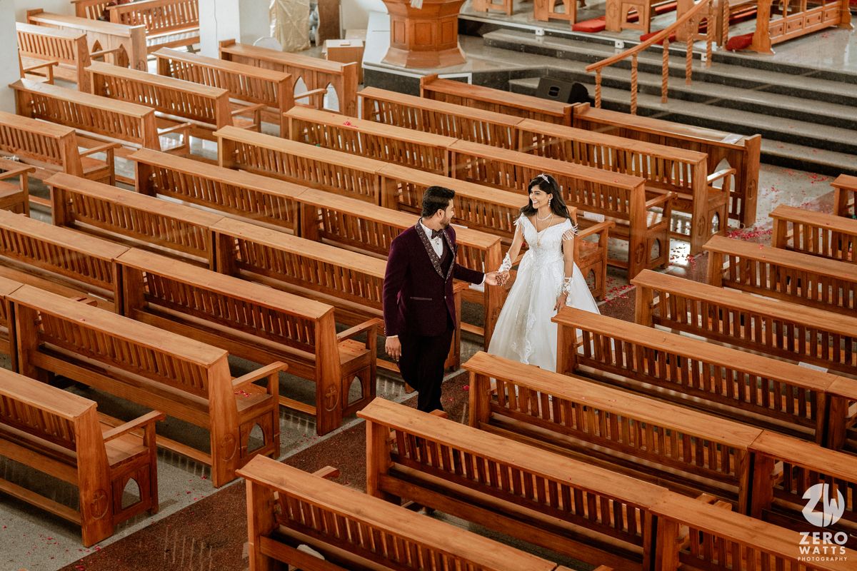 Bride and groom walking down the aisle of a wooden church during their wedding ceremony.