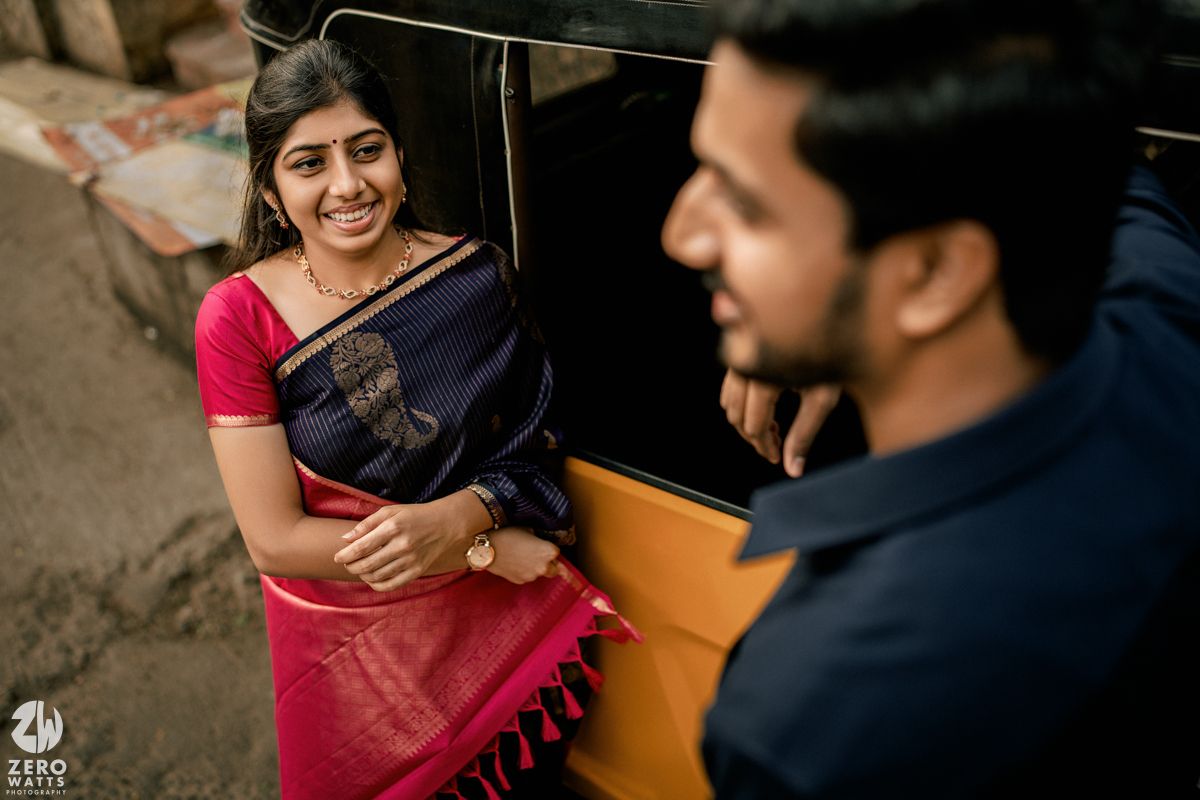 A couple in traditional Indian attire share a joyful moment during their engagement photo session.