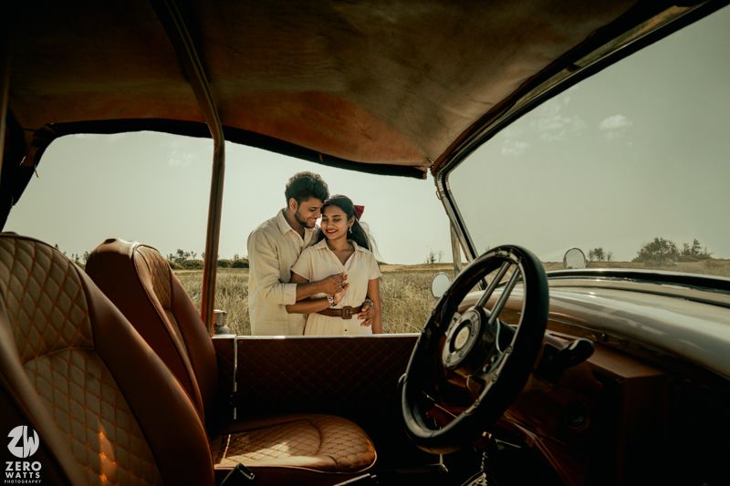 A brown vintage car interior with a rearview mirror and dashboard shown in warm sepia tones.